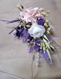 Dos ramilletes de flores para el novio con gardenia y otro más pequeño para el padrino